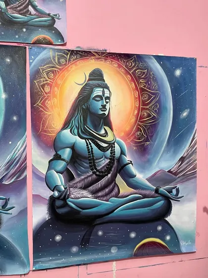 A close-up of one of the finished Shiva paintings, showing the detailed mandala and the galaxy background.