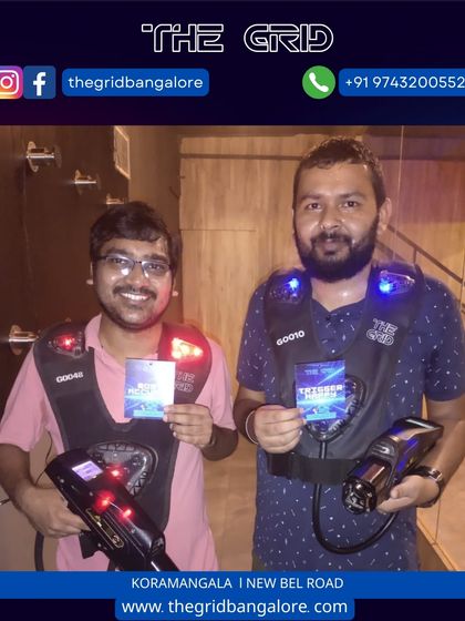 Two players showing their "Most Accurate" and "Best Player" awards after a laser tag game.