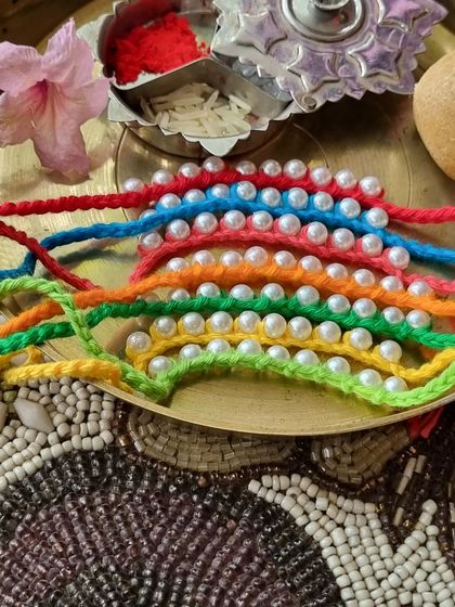 This collection of pearl-studded rakhis comes in many bright colors. They offer a simple, elegant, and modern look for the festival.