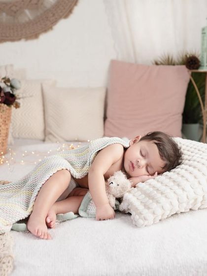 We create pictures that are dream-like and peaceful. This little one is sleeping so soundly on a comfy pillow, wrapped in a soft blanket in our lifestyle studio setup.