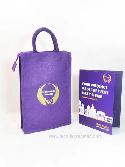 A vibrant purple jute bag with a custom gold logo, paired with a matching file folder for a corporate awards event. This shows how we can coordinate different items for a cohesive look.