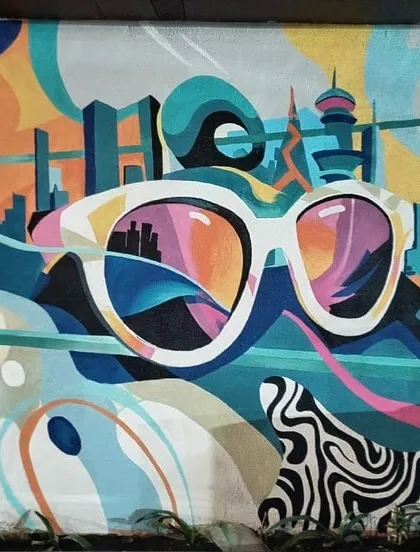 An abstract and colorful mural featuring a pair of sunglasses reflecting a city skyline. This piece was designed to be modern, energetic, and a great spot for photos.