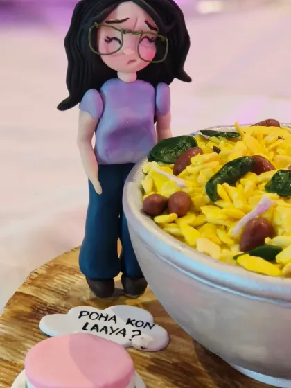 The other figurine from the "Poha" cake, with a speech bubble asking "Poha kon laaya?" (Who brought the poha?).