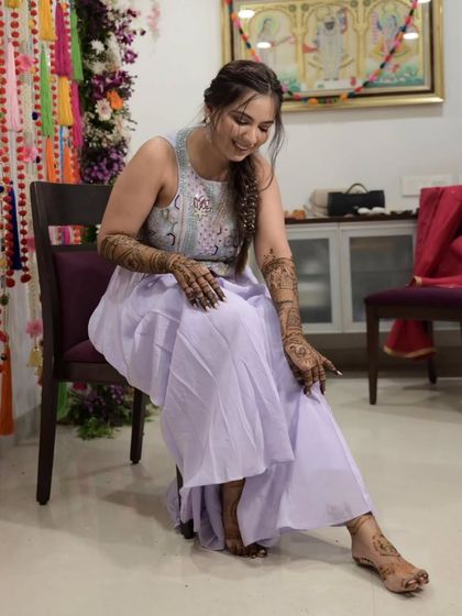 A full-length view of the bride, showing how the mehandi on her hands and feet creates a complete, cohesive bridal look.