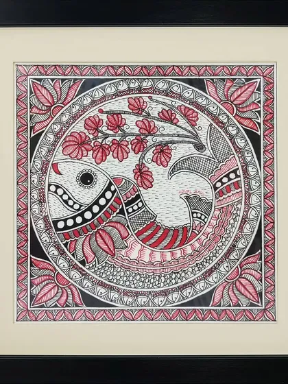 The sacred 'Om' symbol is creatively represented as a fish in this Madhubani painting by Anu Bansal. The piece is filled with intricate floral and geometric patterns in a striking red, black, and white palette.