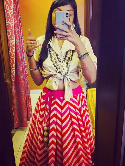 Style is all about expressing yourself. Here, I've created a modern fusion look by pairing a classic ZARA shirt with a vibrant lehenga skirt from Chandni Chowk. This is a great example of how we can mix high-street fashion with traditional pieces for a fun sangeet or mehendi outfit.