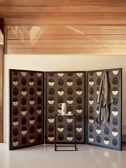 This screen, covered in the 'Royal Emblème' wallpaper, showcases the design's versatility. Crafted from paper pulp, the pattern offers a modern yet artisanal feel, perfect for creating distinct zones within a space.