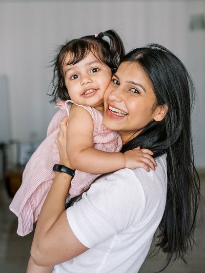 A mother holding her daughter, both looking happy and relaxed. A beautiful portrait that captures their close bond.