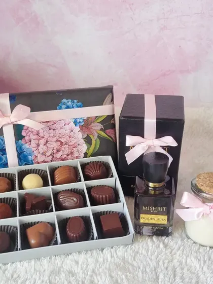An unboxed view of our Mother's Day luxury gift, showcasing the perfume, candle, and our box of 12 handmade pralines.