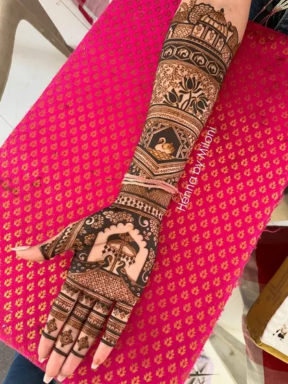This bridal arm design is a masterpiece of traditional motifs. It features a swan, elephants, lotuses, and a peacock, all intricately drawn.