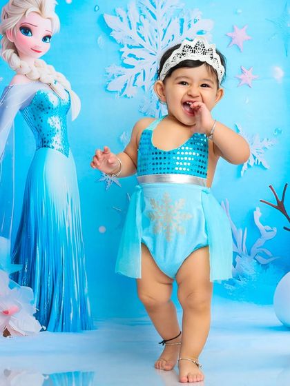 Taking her first steps in Arendelle. This joyful photo captures the excitement and wonder of our Frozen-themed session.