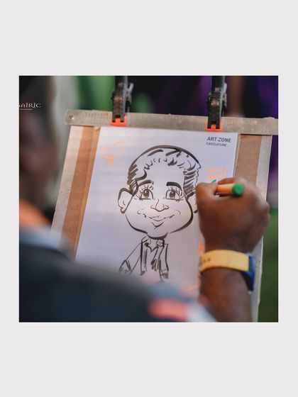 A close-up of the artist's hand as they create a caricature. This type of interactive entertainment is always a hit with guests of all ages.