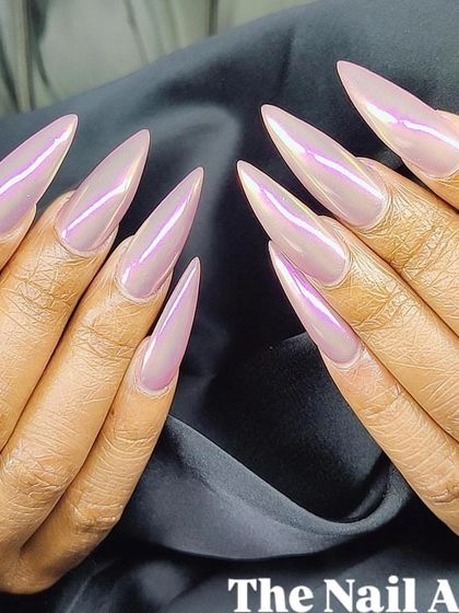 A close-up of the iridescent stiletto nails, showcasing the sharp shape and the beautiful pink and lavender color shift of the chrome powder.