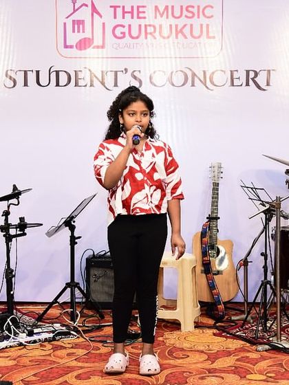 A young Western vocal student confidently takes the stage at our concert. We provide a professional setup with full sound equipment to give students a real concert experience.