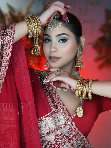 A classic red bride look is always in demand. This look features a modern twist with a sharp green winged liner, paired with traditional red attire and gold jewelry.