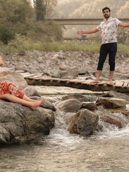 A scenic shot of the couple enjoying the natural beauty of their pre-wedding location by the river.