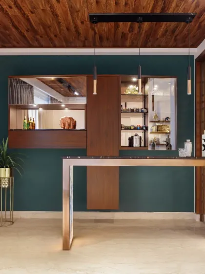A suave bar corner in the Rue 32 living room. The minimalist bar table, with its black granite top and textured tile base, is paired with a wall-encased wood cabinet that displays a collection of travel mementos, making it a welcoming hub for vibrant soirées.