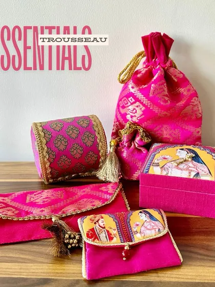 These are the essential elements of a royal trousseau. I’ve curated a set of matching rani pink items, including a bangle case, potli, and jewelry box, all featuring a classic Raja-Rani theme.