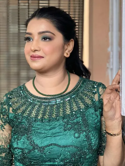 Another angle of the green smokey eye look. It's a modern and chic choice for a party, showing how you can incorporate color into a classic makeup style for a stunning result.