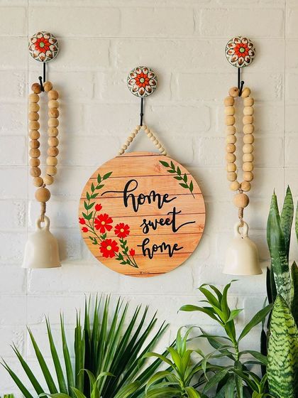 A beautiful wall setup featuring our 'Home Sweet Home' wooden sign and two rustic beaded ceramic bells. This combination creates a warm and welcoming entrance, perfect for any home.