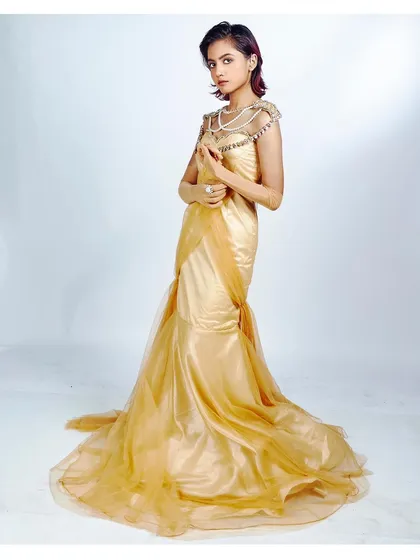 For a classic lookbook image, clean lighting and elegant posing are key. This full-length shot of a golden mermaid gown showcases the entire silhouette, from the detailed bodice to the flowing train, against a simple white background for a professional, high-fashion result.
