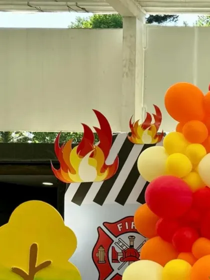 Close-up of the flame cutouts and balloon garland, showing the vibrant red, yellow, and orange color scheme.