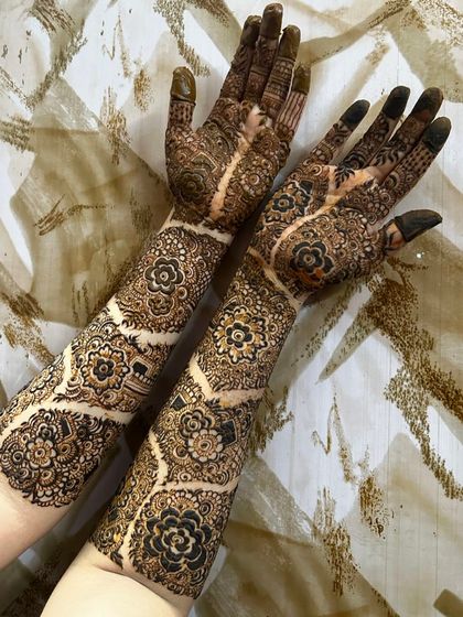 The dried paste of the floral medallion design, showing the clean lines and intricate work before the stain develops. The pattern flows beautifully from the palm to the elbow.