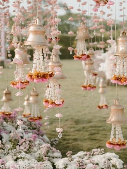 A close-up of the delicate floral bells and kalire hanging from the trees, adding a whimsical and traditional touch to the wedding decor.