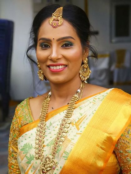 A close-up of Deepu's housewarming look, showing the detailed eye makeup and traditional gold jewelry.