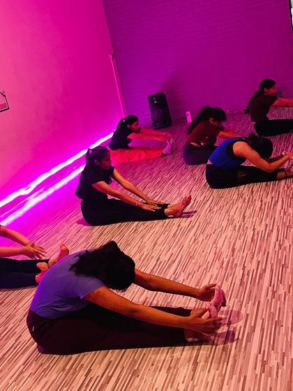 A cool-down is just as important as the workout itself. Here, my class is performing the seated forward bend (Paschimottanasana) to stretch their hamstrings and release tension from their backs.