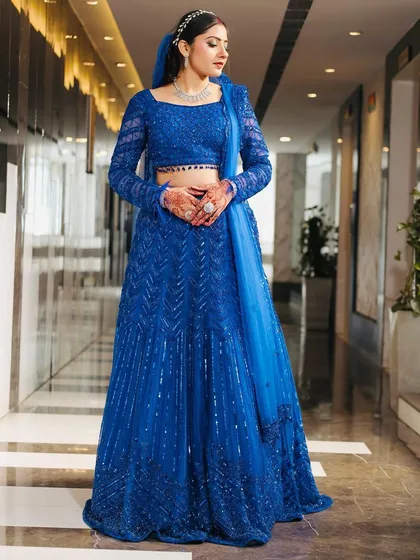 A full-length portrait of a client in her stunning royal blue reception lehenga. The monochromatic look is both modern and timelessly elegant.