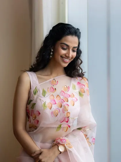 A candid and happy shot from the pink floral saree series. The natural light and relaxed pose create a feeling of effortless beauty and charm.