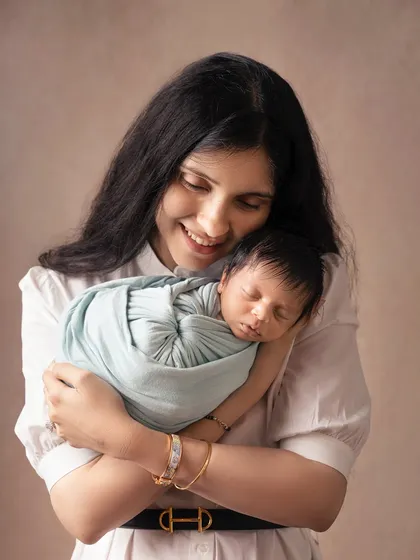 A mother's warm embrace. This portrait shows a mother holding her swaddled baby close, a simple yet profoundly emotional image of comfort and love.
