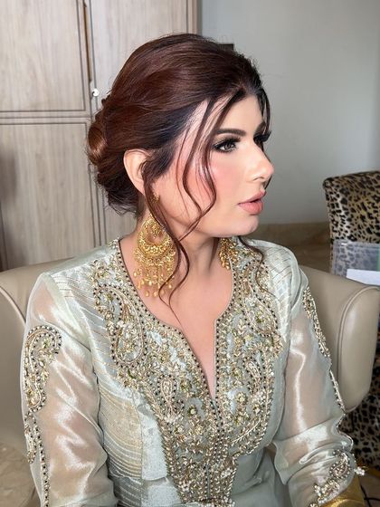 A side profile showing the beautiful updo and the flawless finish of the makeup. The look is sophisticated and chic.