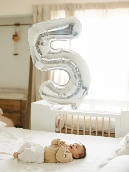 Celebrating five months with a big number 5 balloon. This at-home milestone session for my son Caden shows how simple props can create fun and memorable photos right in your own space.