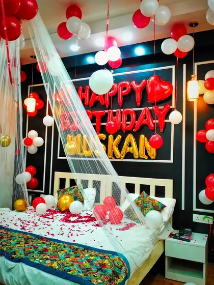 A beautiful shot of the bed decor, with the "Happy Birthday Muskan" balloons clearly visible behind the delicate white canopy.