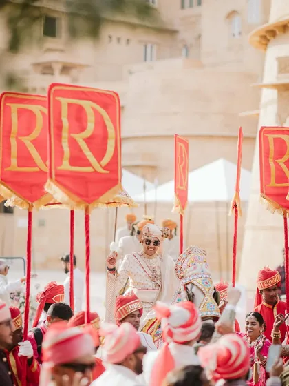 Personalized banners with the couple's monogram, carried during the groom's grand baraat. These custom details add a regal and cohesive touch to the wedding procession.