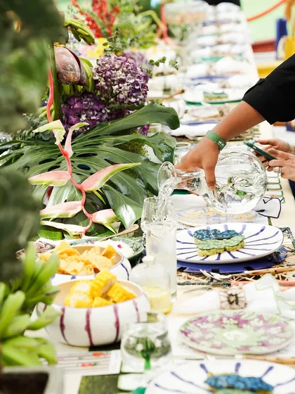 A moment of service at the Farm Rio brunch, with a guest's plate being attended to amidst a vibrant, lush tablescape. It captures the lively and interactive atmosphere of our events.
