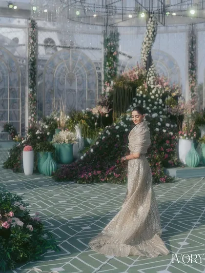 The bride twirls in her magnificent reception gown, set against a backdrop of a stunning floral conservatory. A moment of pure elegance and joy.