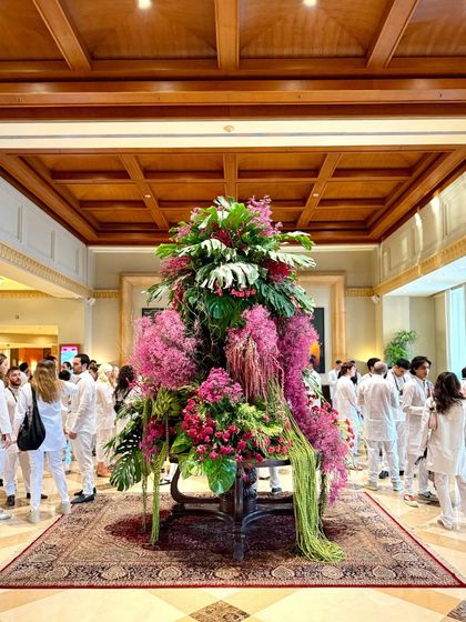 Guests mingle around the grand floral centerpiece. My installations are not just to be looked at; they are designed to be part of the guest experience, a beautiful backdrop for memories.