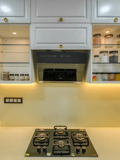 Open cabinets in the PU kitchen, showing organized spice jars and glassware.