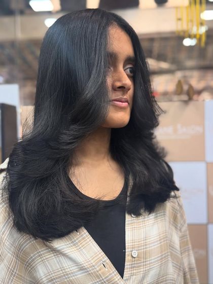 This angle shows the beautiful side-swept layers and the healthy, natural shine of the hair after a fresh cut.