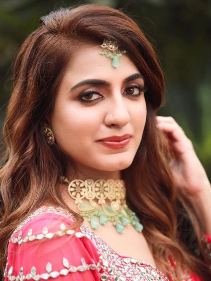 A close-up portrait that highlights her flawless skin and the beautiful details of her makeup and jewelry.