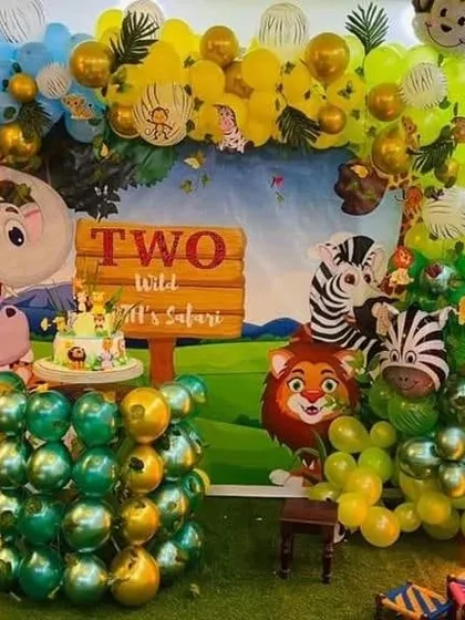 A 'Two Wild' safari-themed second birthday party with a large backdrop and character cutouts.