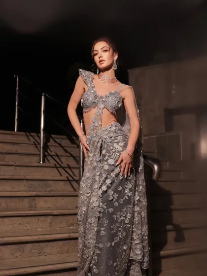 A full-length shot on a staircase at night. The styling creates a dramatic and mysterious mood, perfect for a grand evening event.