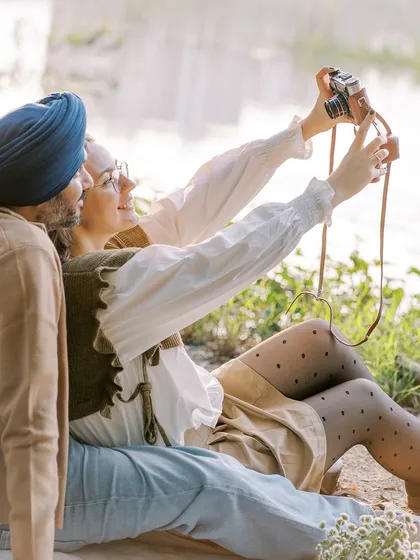 A fun, candid moment where the couple takes a selfie with a vintage film camera. It shows their playful side and their shared love for creating memories together.