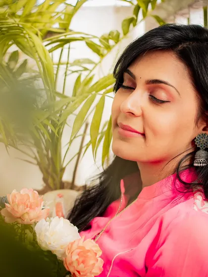 A serene portrait with eyes closed, holding flowers. This image evokes a sense of peace and contentment.