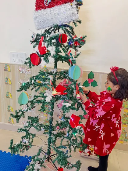This student shows her artistic flair while decorating the Christmas tree.