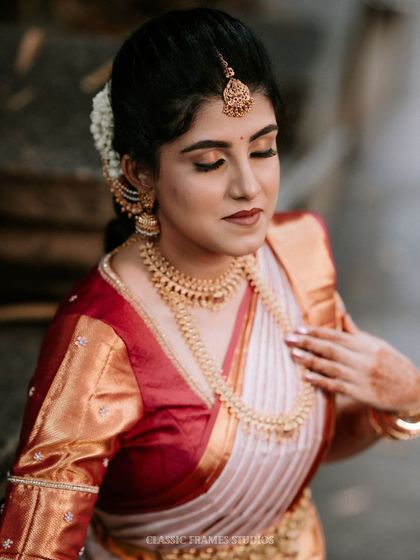 An elegant bridal portrait from an engagement ceremony. The bride's classic South Indian look, with a beautiful saree and gold jewelry, is captured with grace.