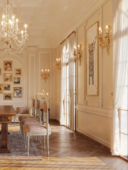 This study feels like a step back in time, exuding timeless elegance. The design features a long wooden table that can serve as a desk or a conference table, set against a wall of beautifully curated art.